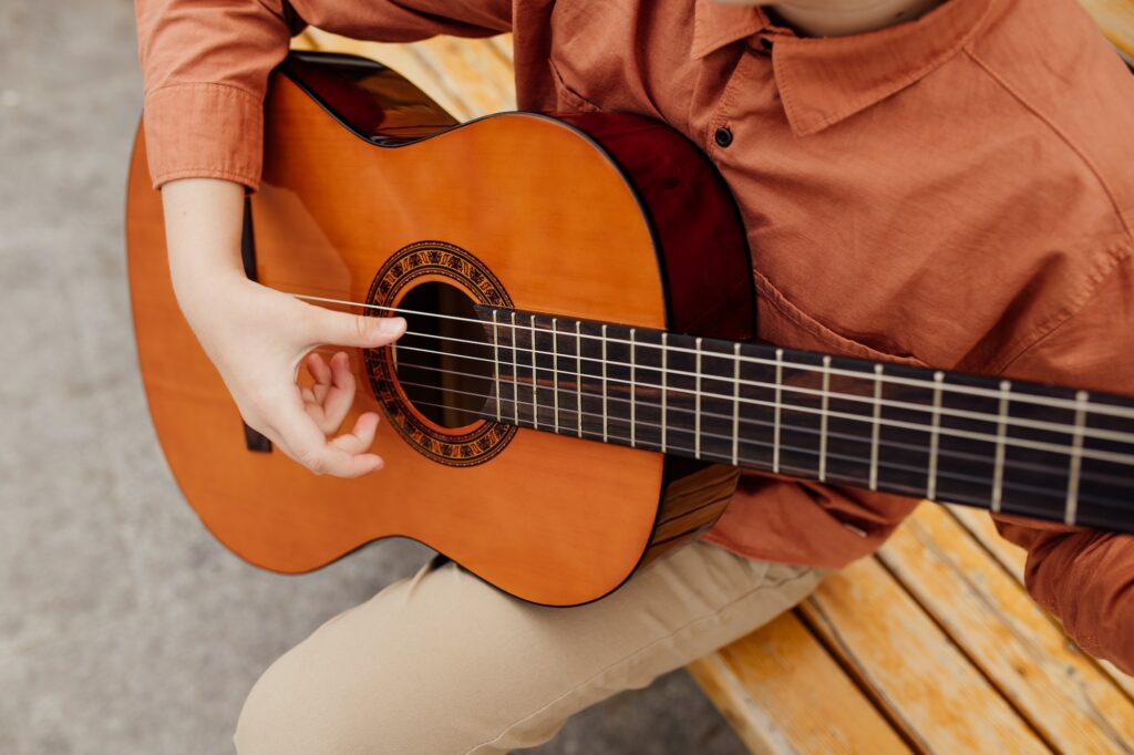 close-up, child hand with guitar, outdoor, classic guitar